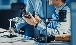 Researchers in a lab working on a robotic arm