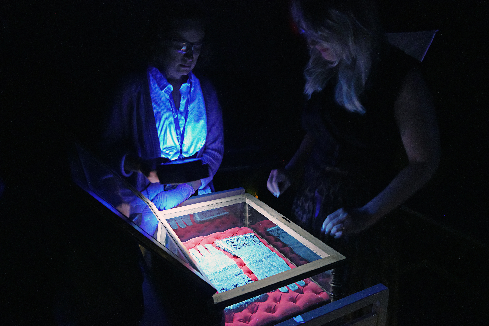 Gadomski and Meyer examining the gloves with ultraviolet light.