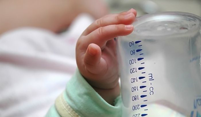 Infant drinking from a bottle