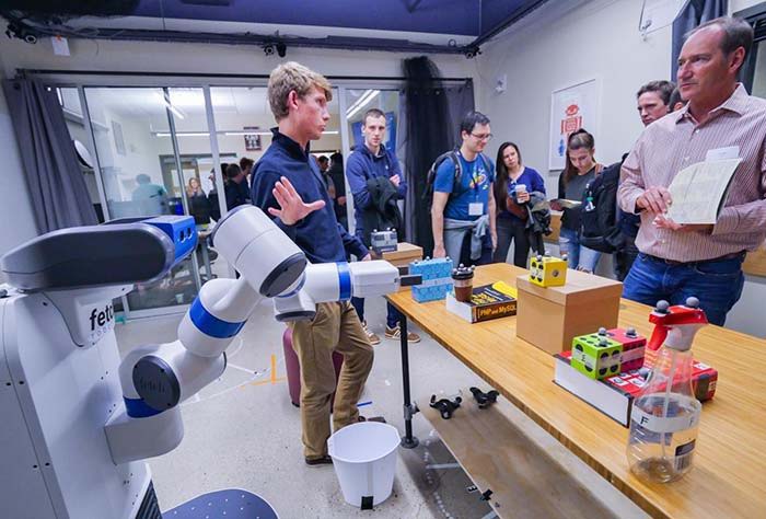 Connor Brooks, a graduate student in computer science, demonstrates a robotic system that responds to spoken commands.