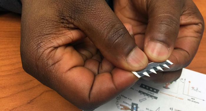 Ohio State chemist Abraham Badu-Tawiah holds a prototype test strip for diagnosing diseases including cancer and malaria.