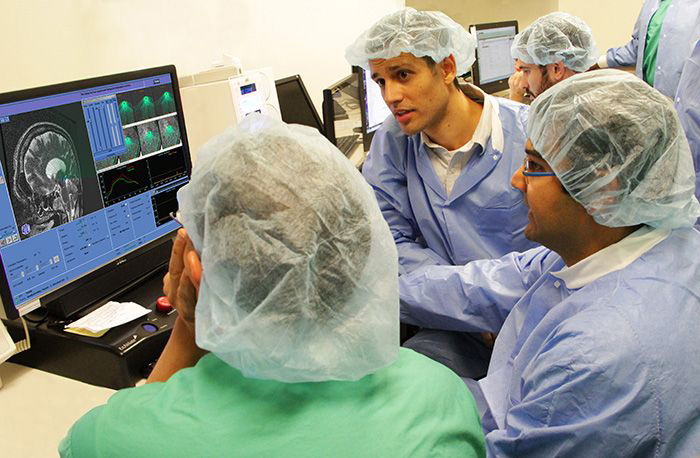 Image: Doctors view ultrasound image of patient's skull.
