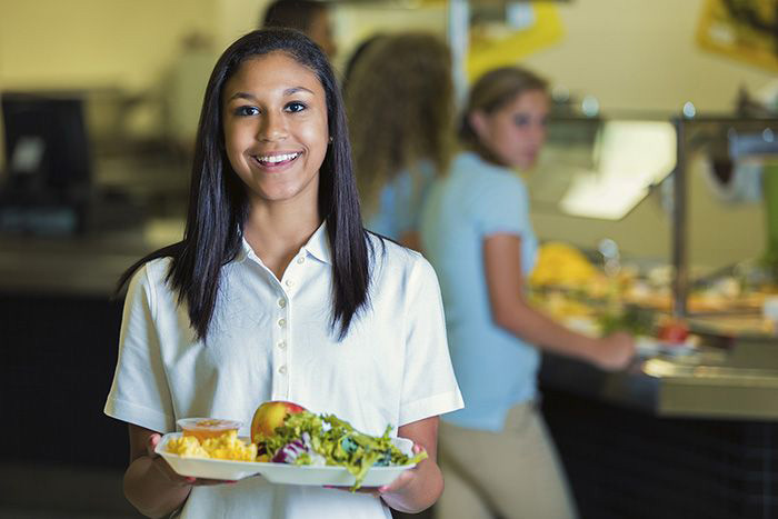Student with cafeteria food tray