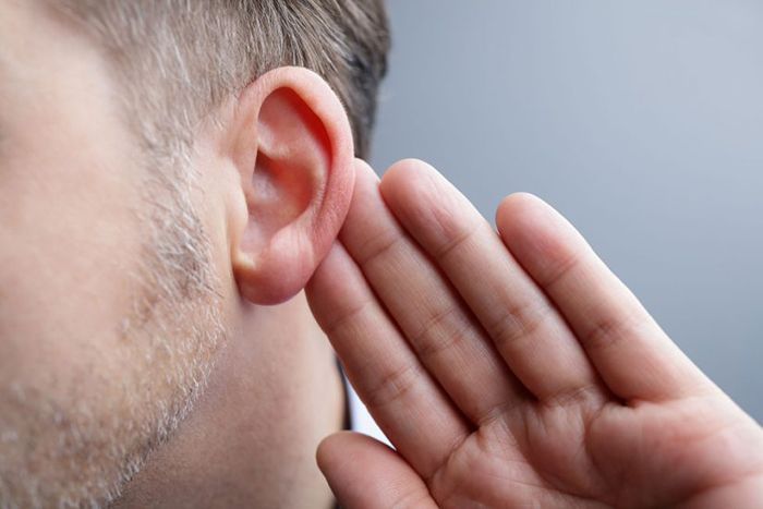 Man with hand to ear