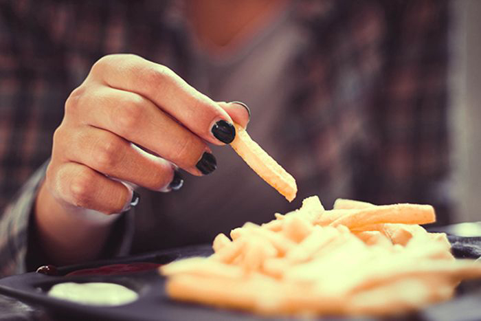Image of teen eating french fries