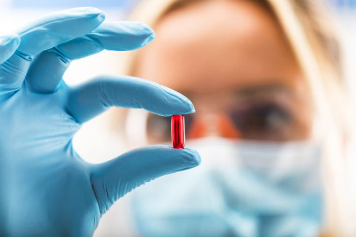 Researcher examining pill