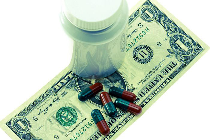 Image of pills on a dollar bill
