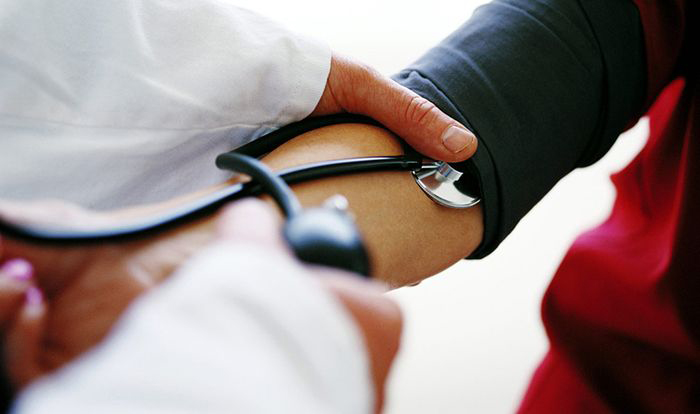 Doctor taking patient's blood pressure
