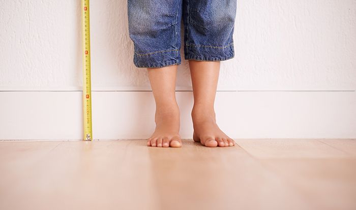 Image of child standing against a wall