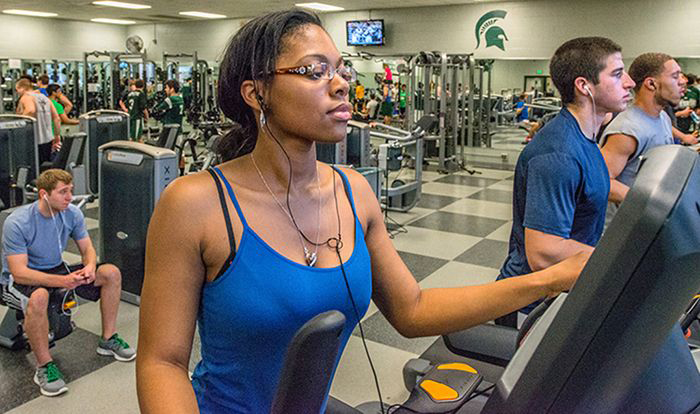 Men and women using exercise machines