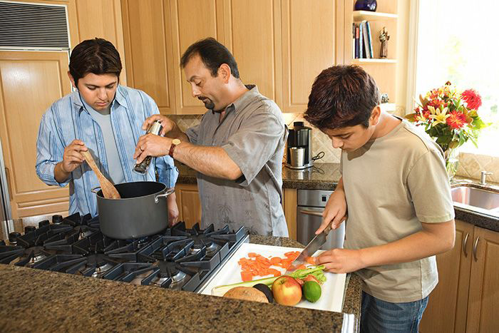 Image: Father and sons prepare meal.