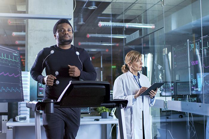 Man on treadmill being monitored by doctor