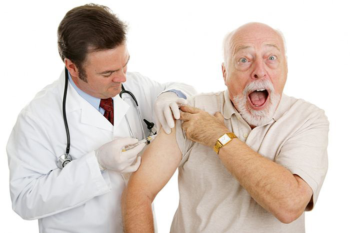 Image: doctor giving male patient a shot.