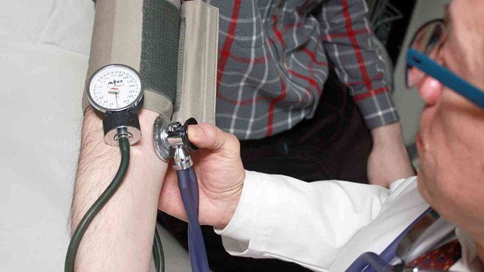 Image of doctor taking a patient's blood pressure