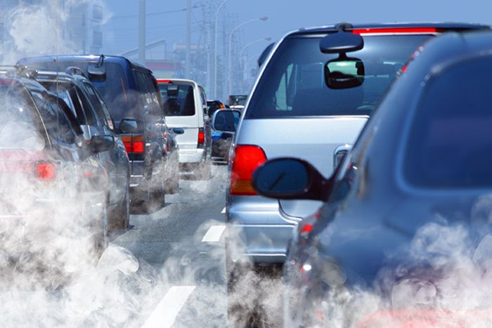 Cars in traffic emitting exhaust