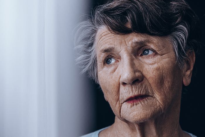 Older woman staring out a window