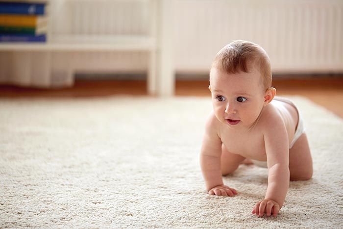 Baby crawling on rug