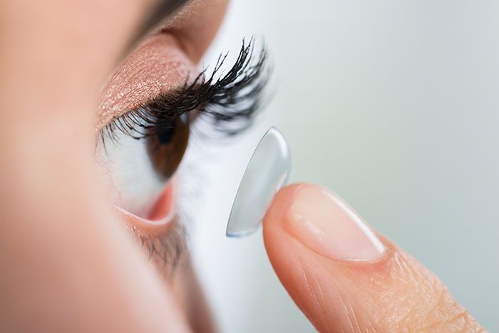 woman applying contact lenses