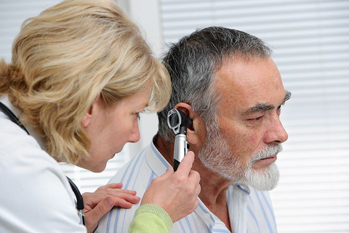 Doctor examining patient's ear.