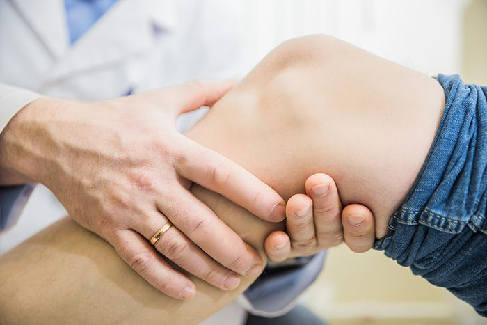 doctor examining patient's knee