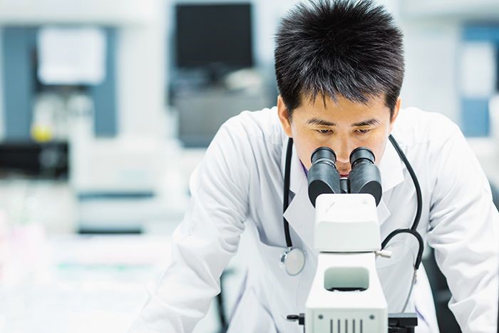Photo of researcher using microscope