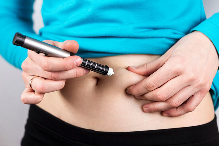Woman giving herself an insulin injection