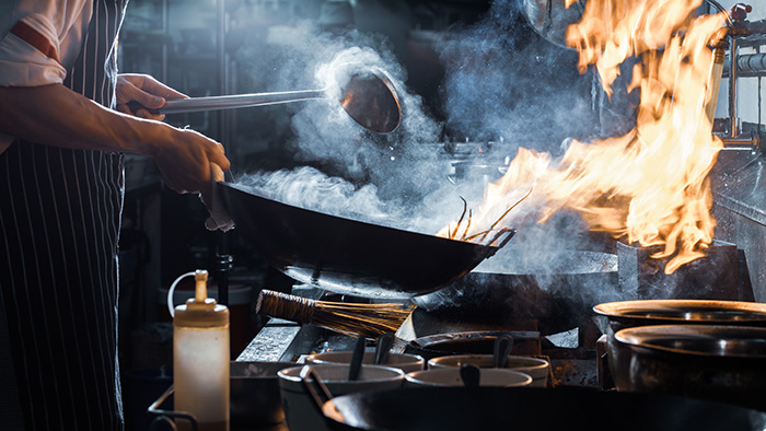 Image: Chef stirs vegetables in a wok.