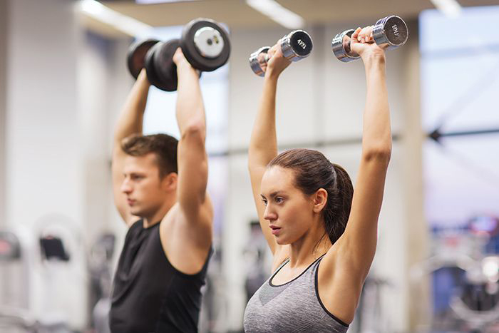 Image: Man and woman lifting weights