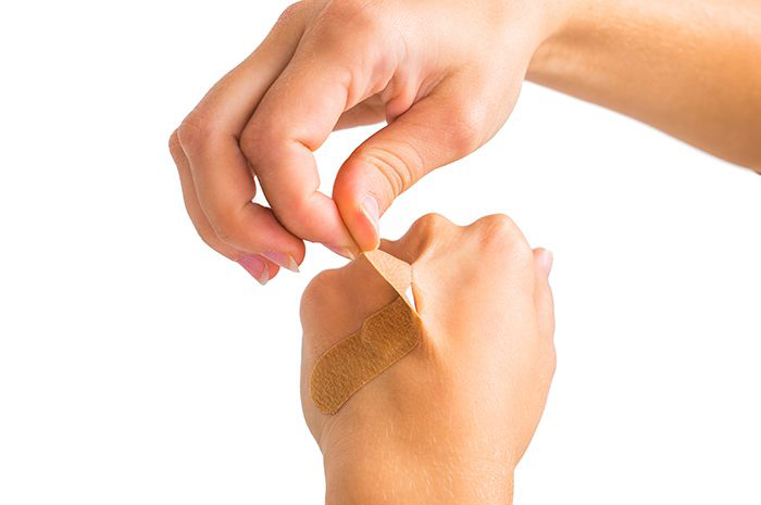 Image: removing Band-Aid from hand