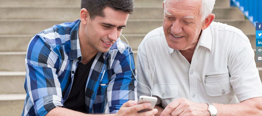 Image: young man and older man looking at a smartphone