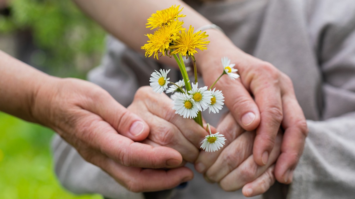 Non-drug interventions for patients with Alzheimer’s are both effective and cost-effective, study shows; Stock image of elderly hands holding flowers