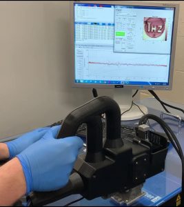 "The handheld THz Scanner is shown in operation."