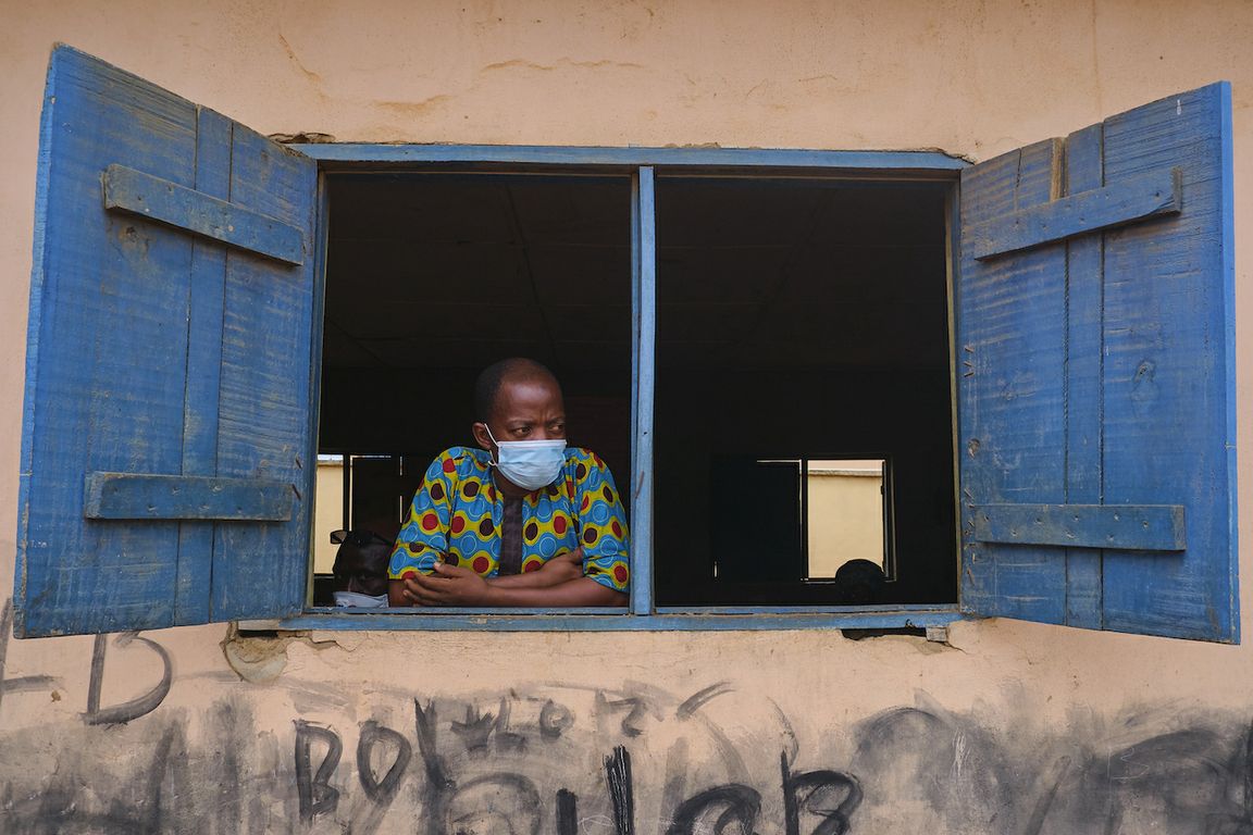 Worldwide, those with ‘traditional’ values adhered more strictly to COVID precautions; A man wearing a mask looks out from a window in Nigeria. The researchers surveyed people in 27 countries across North America, South America, Europe, Asia and Africa.