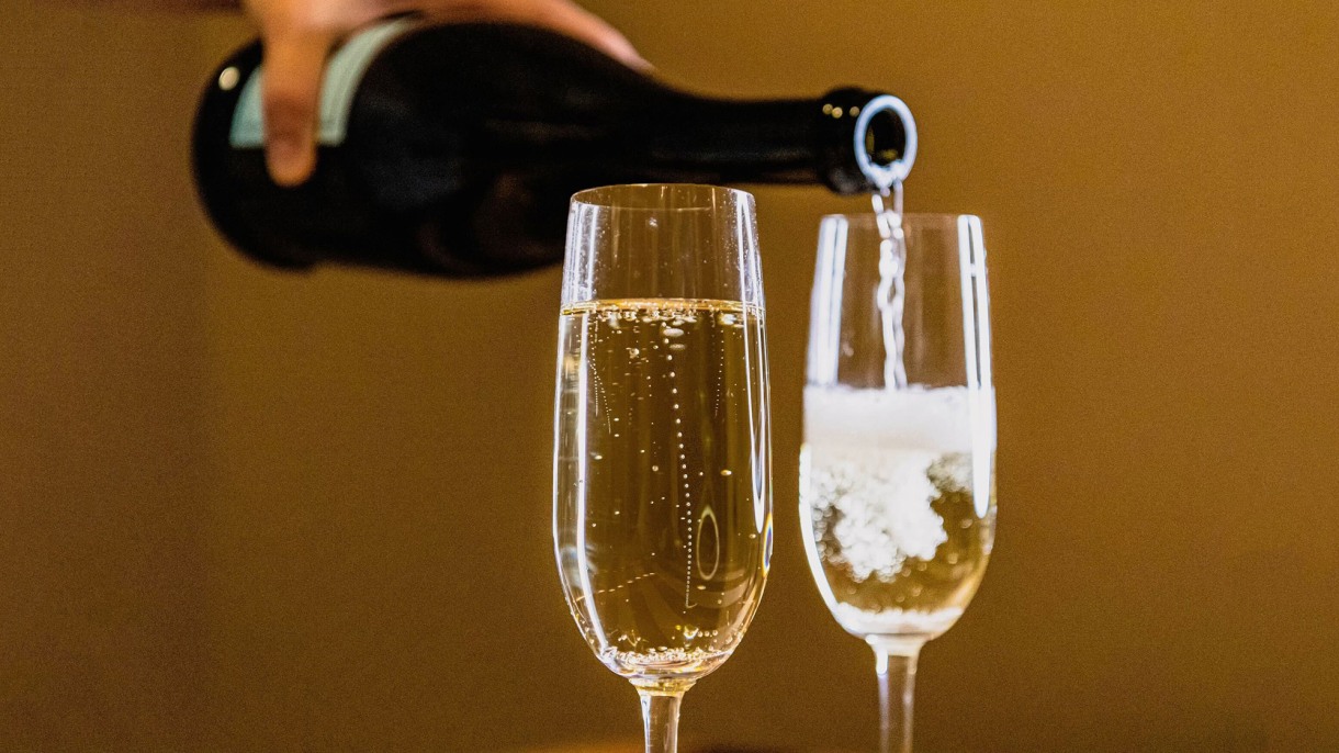Why do Champagne bubbles rise the way they do? Scientists’ new discovery is worthy of a toast; Photo of someone pouring champagne into glasses.