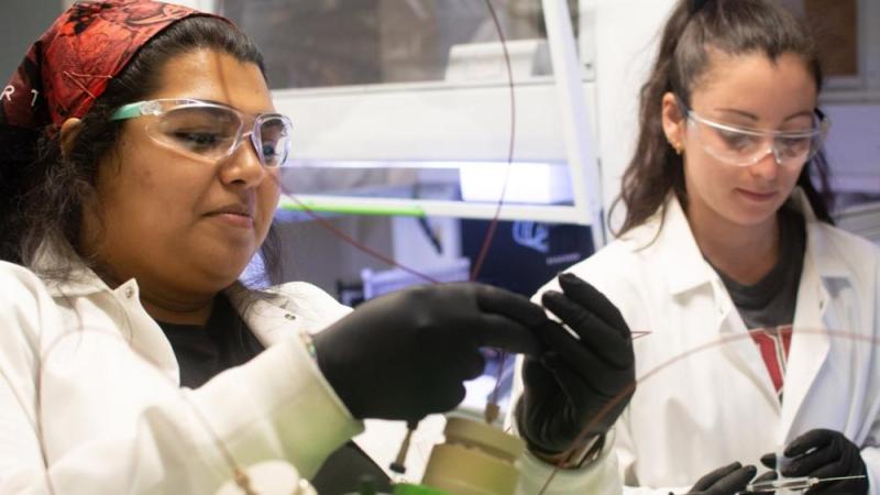 "Ramisa Fariha and Emma Rothkopf inject a sample into the liquid chromatography tandem mass spectrometry machine."