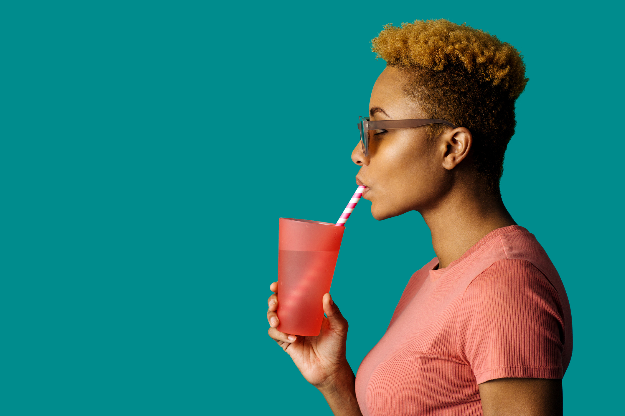 To Uncover New Fluid Flow Laws, Researchers Turn to Drinking Straws; Profile portrait of a cool young woman in pink holding a drinking cup and paper straw