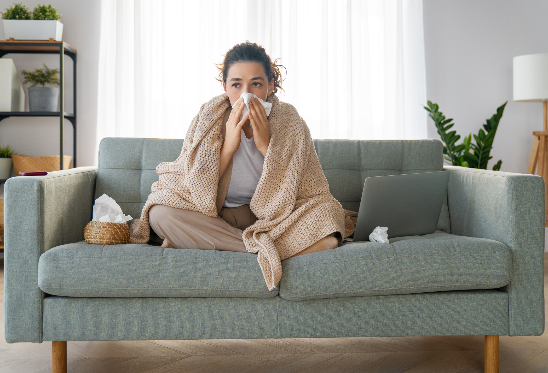 Study Shows Ongoing Symptoms Are Common Three Months After Testing for COVID-19; Girl is holding paper tissue and blowing nose stock photo