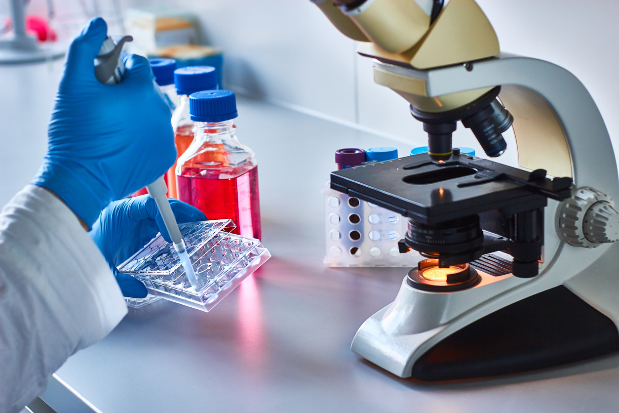 New Polymer Might Reduce Allergic Reactions to Cancer Drugs; Scientist pipetting research samples by the microscope
