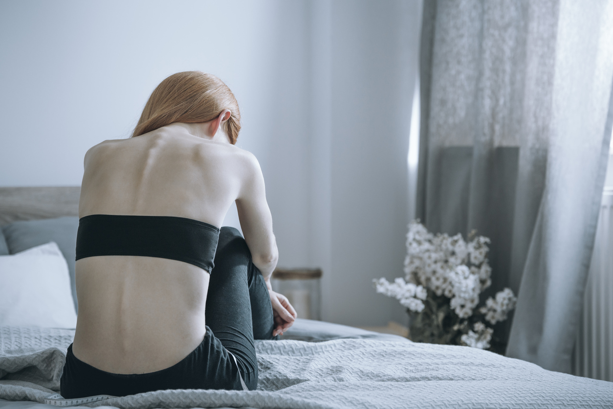 Yale Team Uncovers Promising New Therapeutic for Anorexia Nervosa; Woman with anorexia on bed stock photo