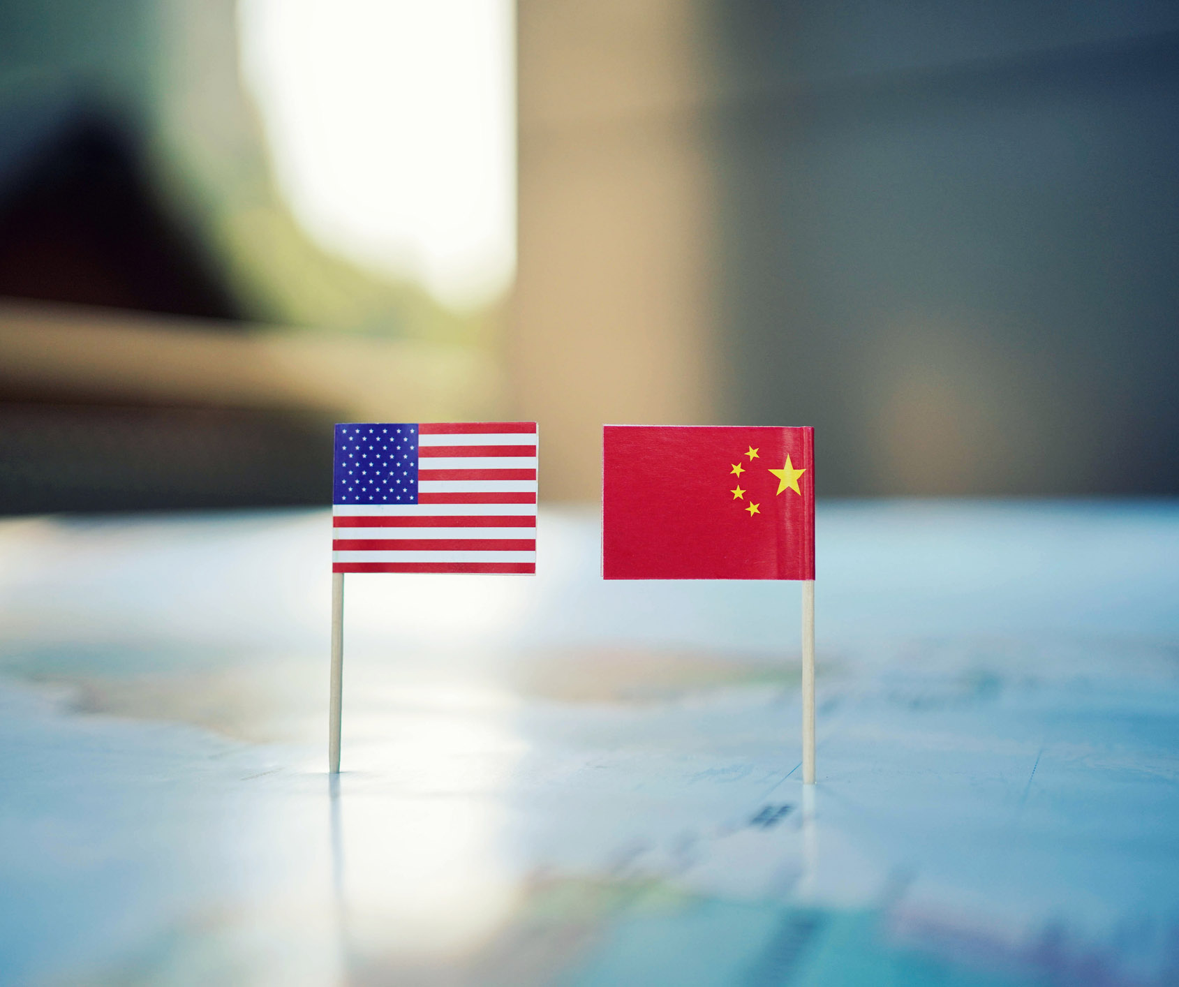 Miniature Chinese and American flags on top of a map