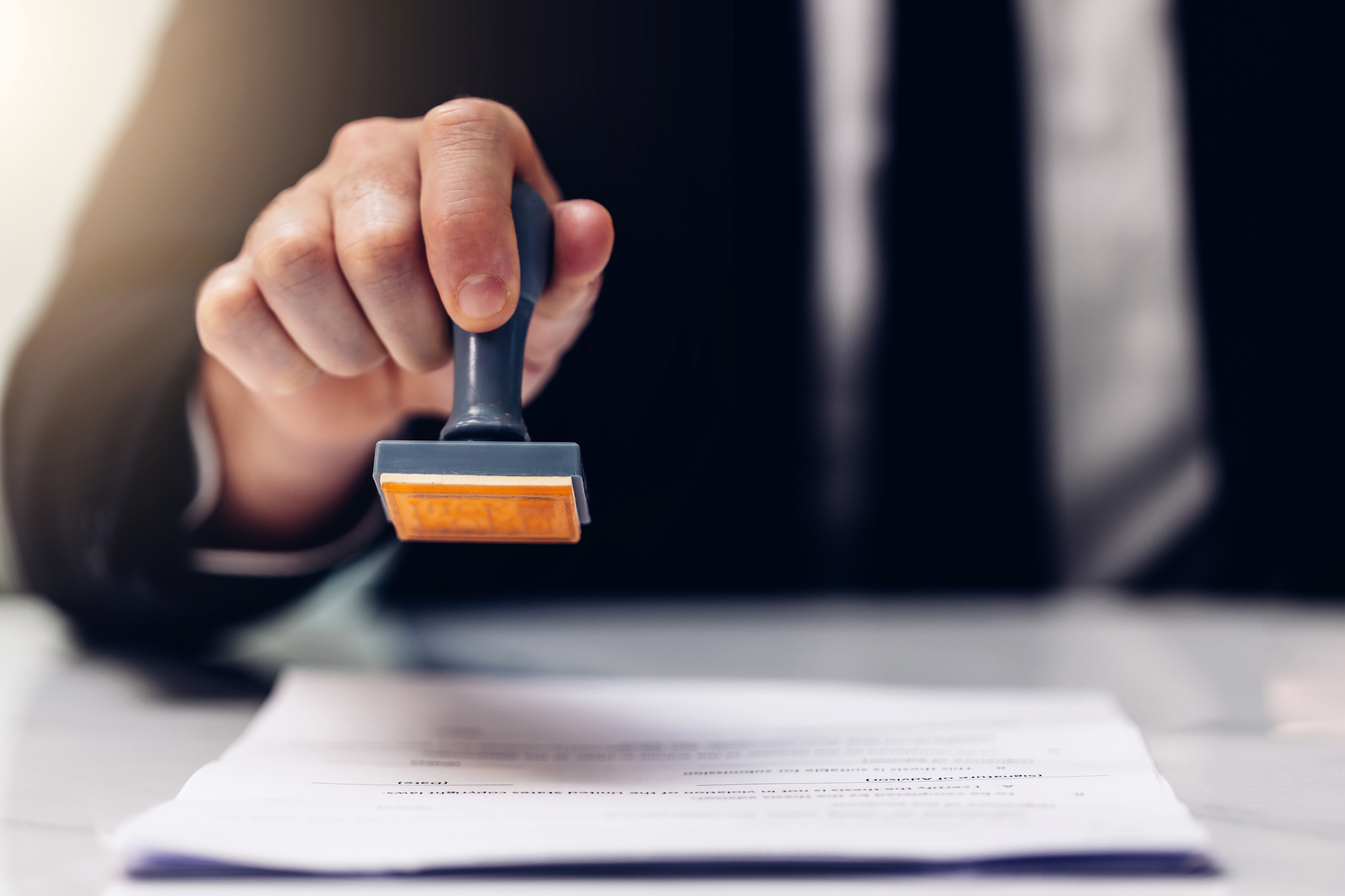 Person stamping documents with a stamp.