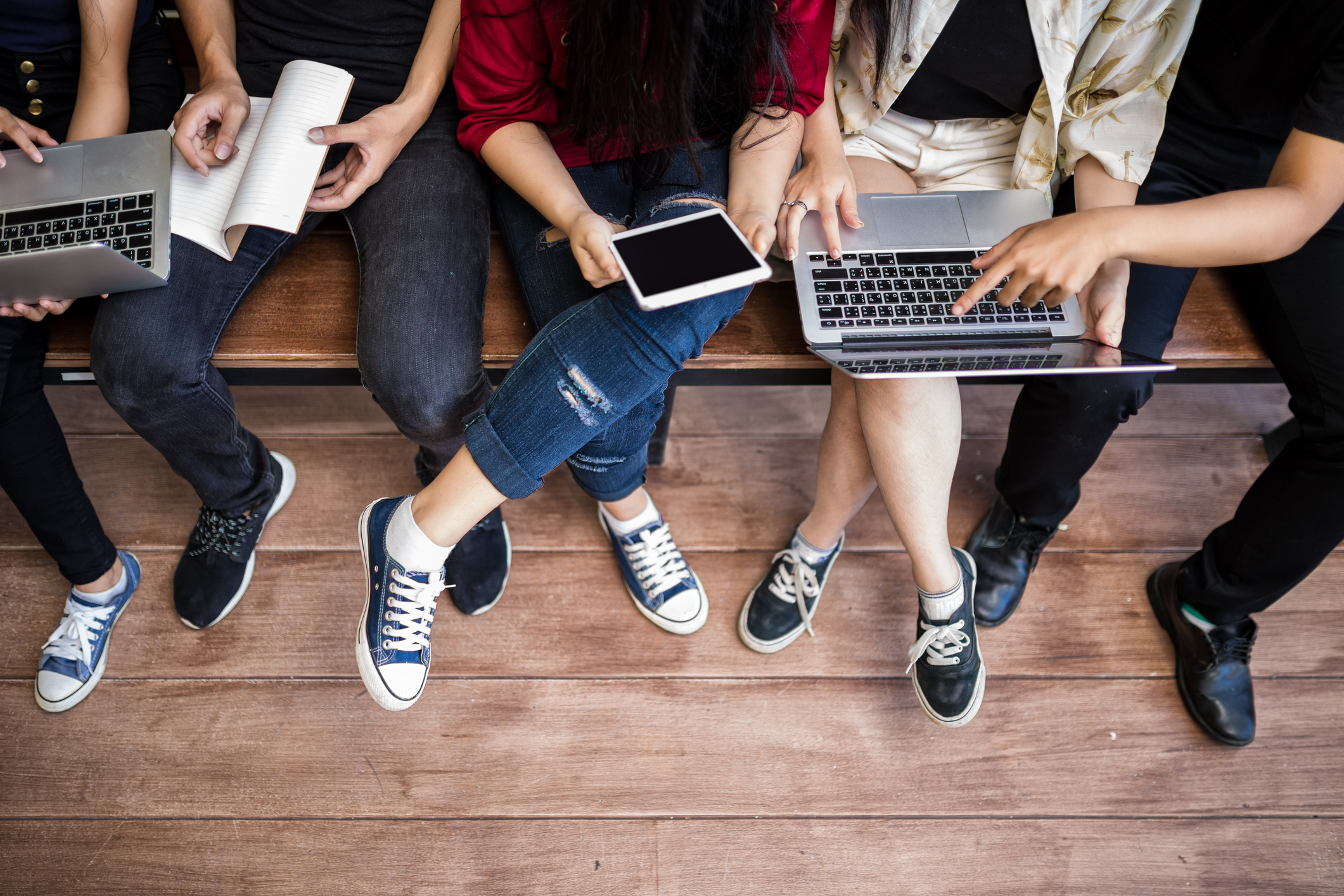 4 students sitting in a row, studying