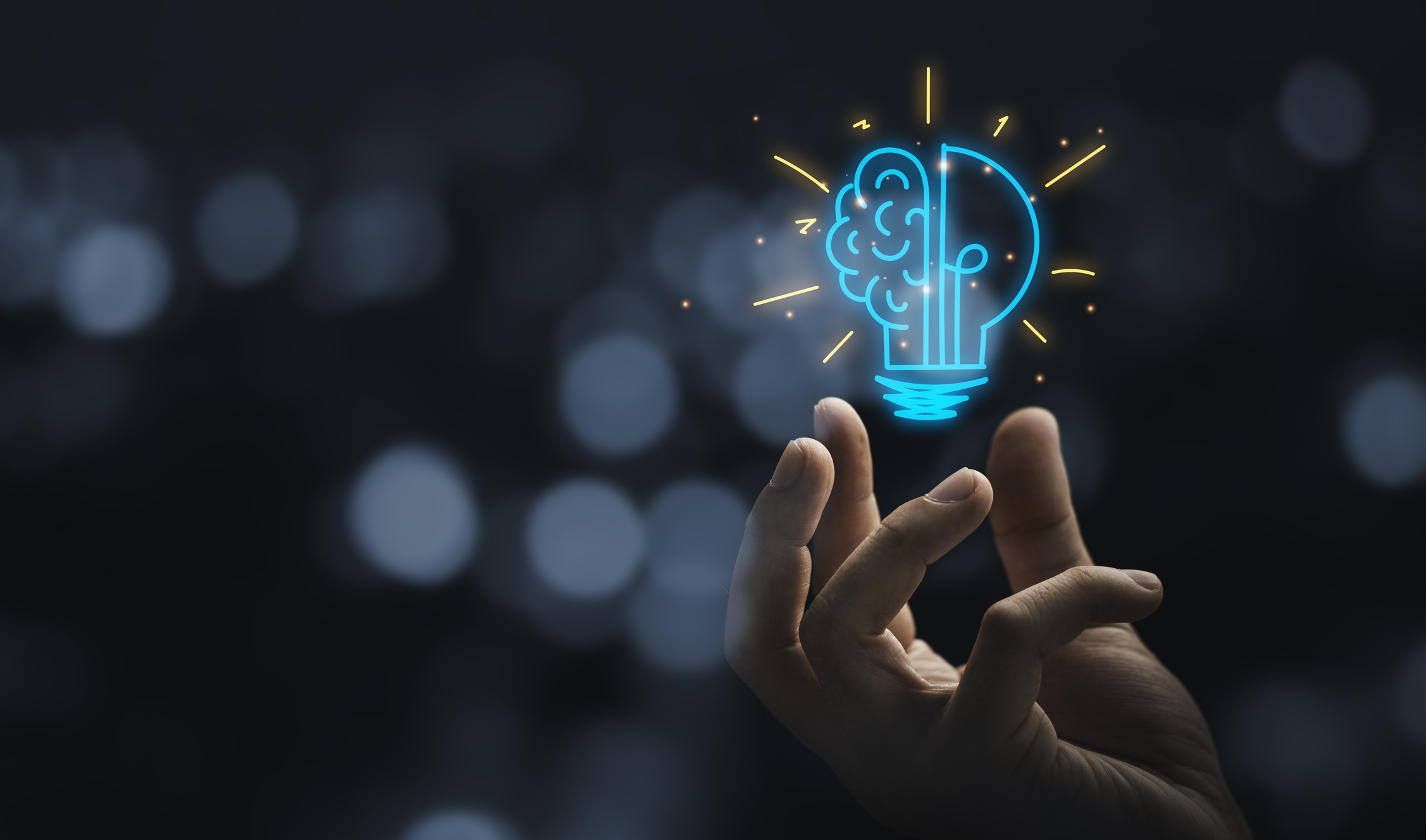 Hand with a drawing of a half-lightbulb, half-brain