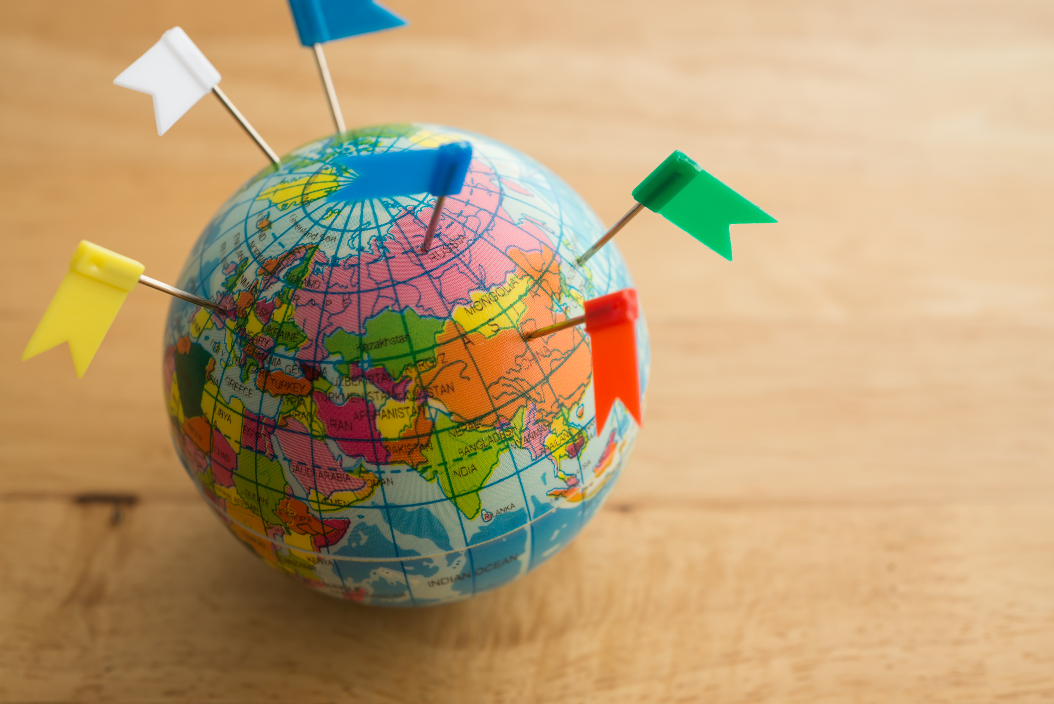 A globe with flags sticking out of it.