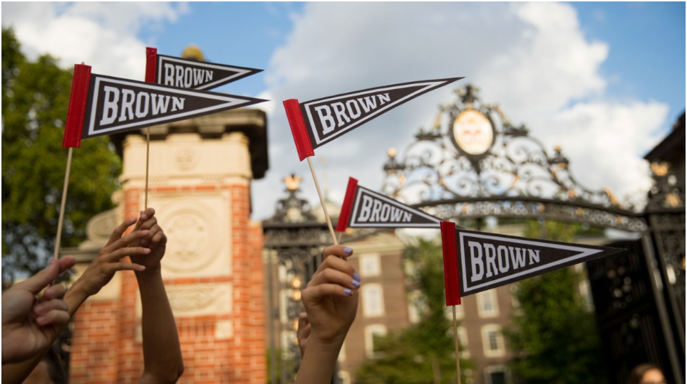hands holding brown university flags