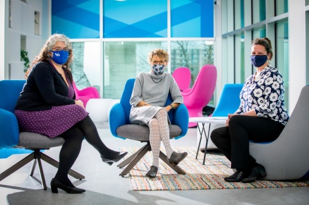 three women sitting with masks, discussing sequencing SARS-CoV2