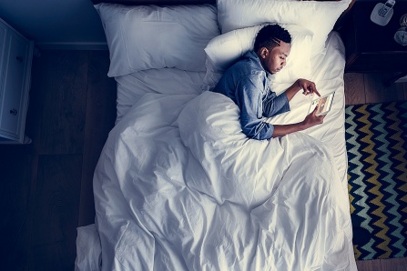 media use before bed depicted by a man laying in bed
