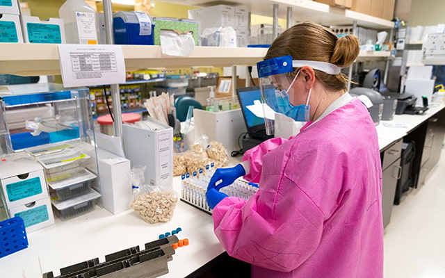 A staff member at the Center for Advanced Laboratory Medicine at UC San Diego Health prepares samples for testing