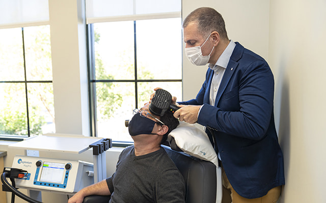 doctor using machine on patient, treating depression