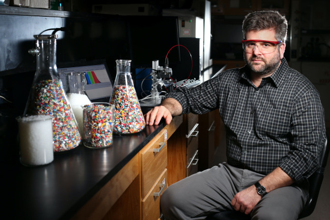 Keith Vorst with bits of recycled bottles inside one of his laboratories in the Food Sciences Building. Vorst is studying potential mitigation strategies such as high voltage atmospheric cold plasma to change the chemistry of PFAS. Larger image. Photo by Christopher Gannon.